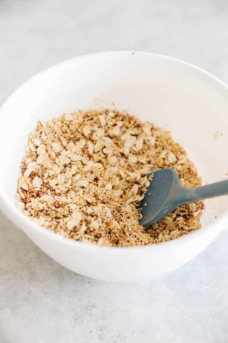quinoa, oats, flax and cinnamon in a large white mixing bowl.
