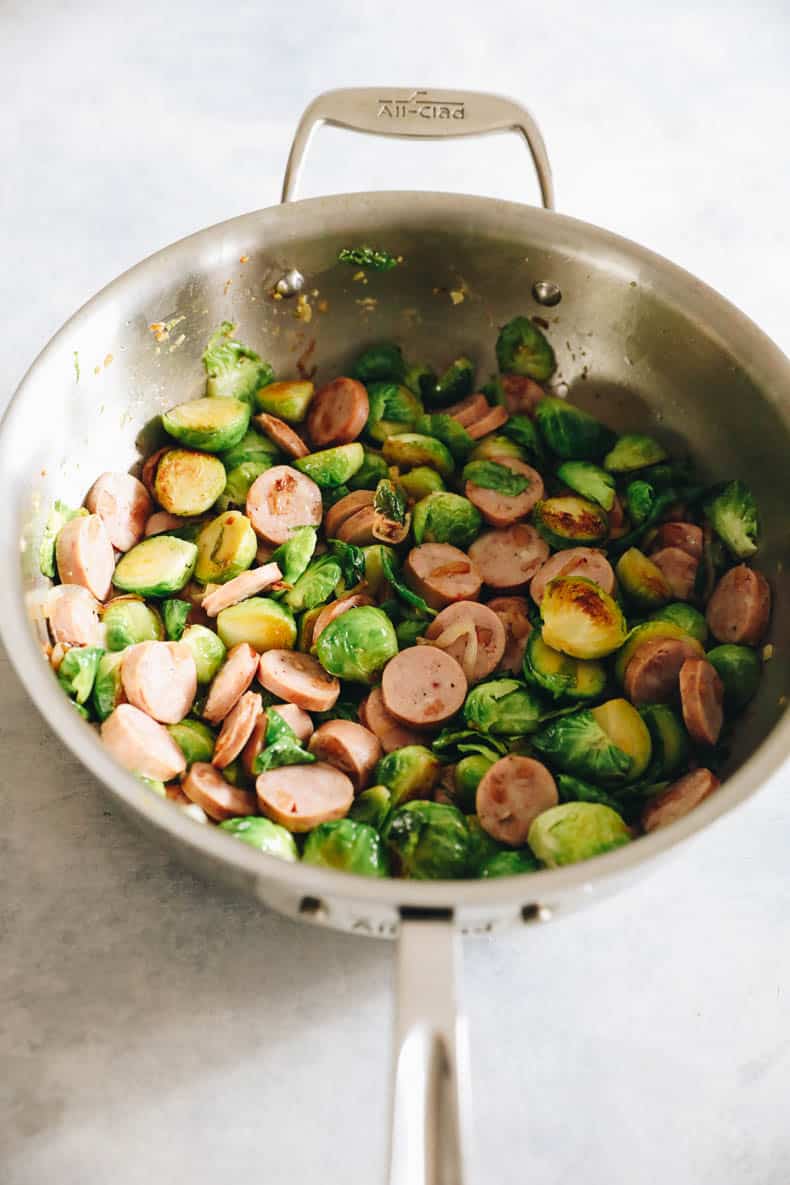 Chicken sausage and brussel sprouts cooked in a large pot.