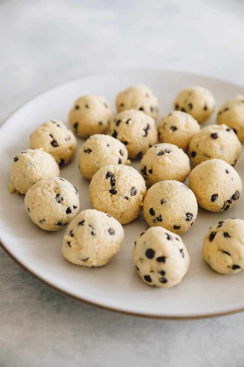 Cottage cheese cookie dough rolled into bite-sized balls on a white plate.
