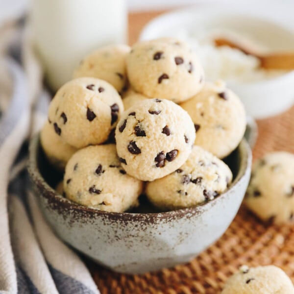 Cottage cheese cookie dough rolled into bite-sized balls with chocolate chips in a blue bowl.