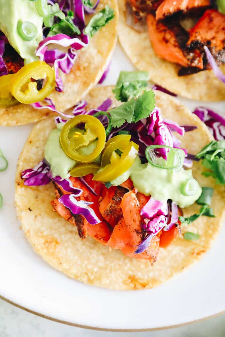 close up of grilled salmon tacos with avocado crema